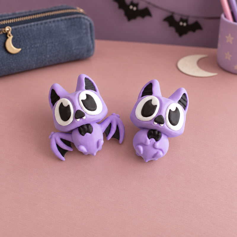 Two purple articulated bats with large black and white eyes in a styled home setting.