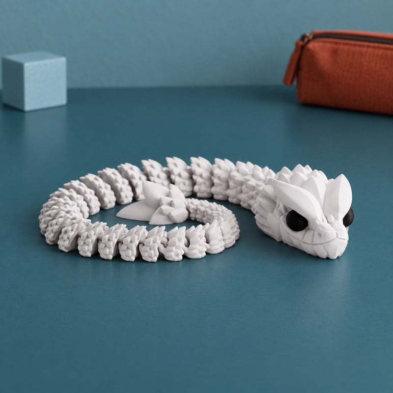 Pale articulated snake curled into a coil with a detailed head in a styled home setting.