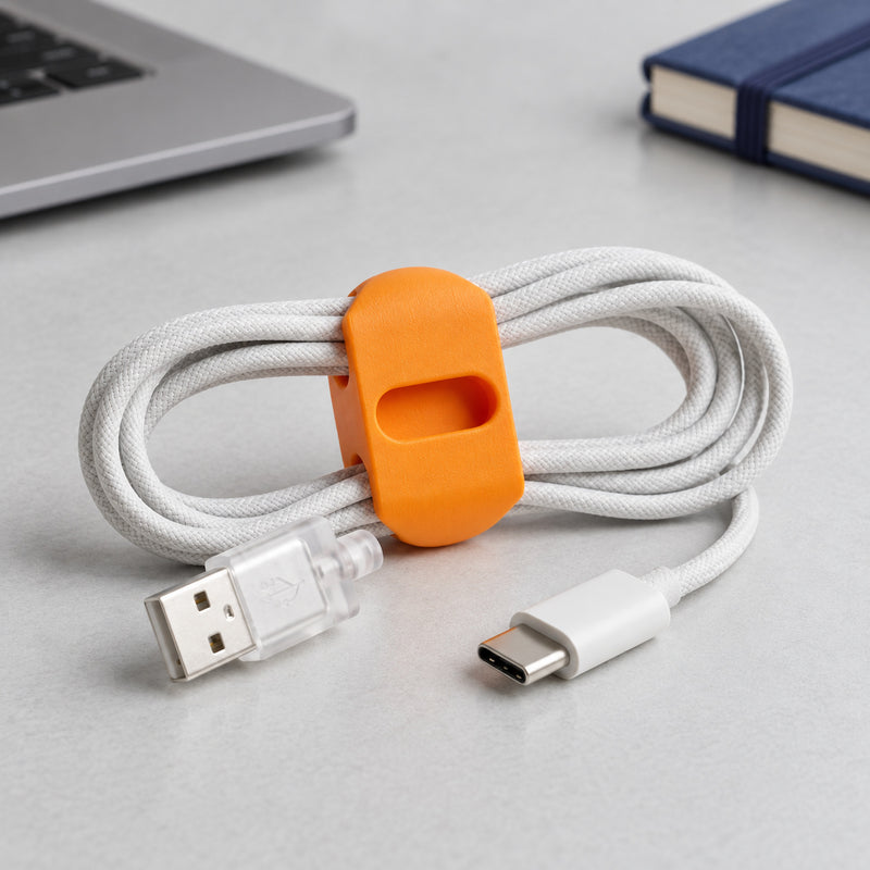 Orange cable wrap around a coiled white cable in a styled home setting.