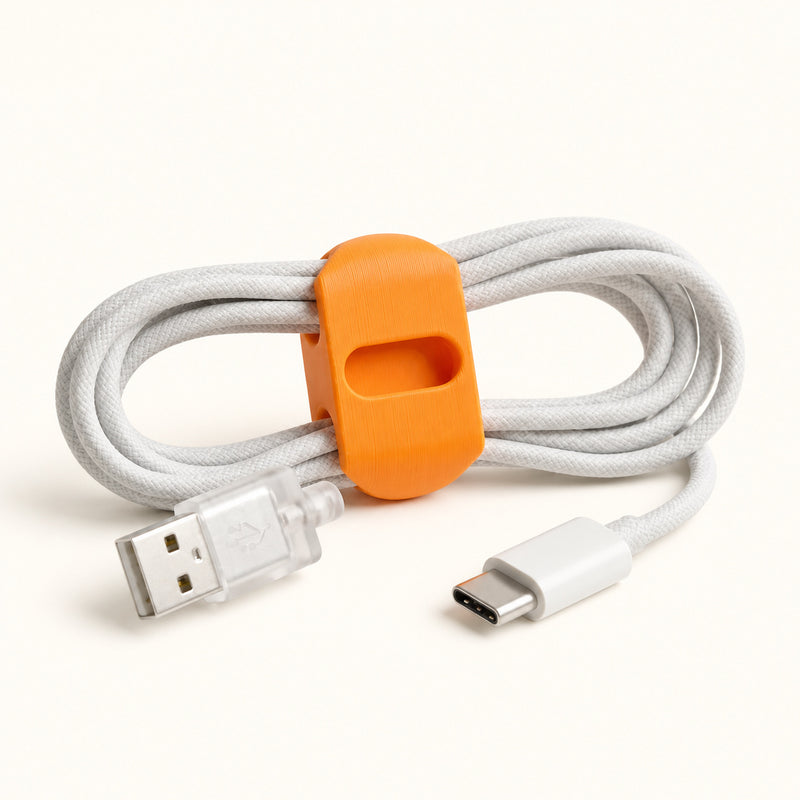 Orange cable wrap around a coiled white cable on a soft white background.