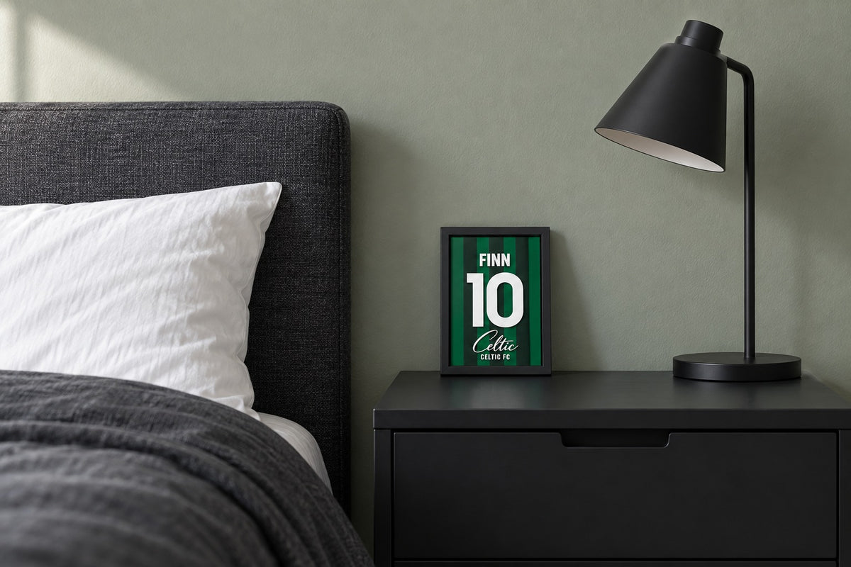 Celtic jersey frame personalized with FINN on a bedside table beside a black lamp and a charcoal duvet.