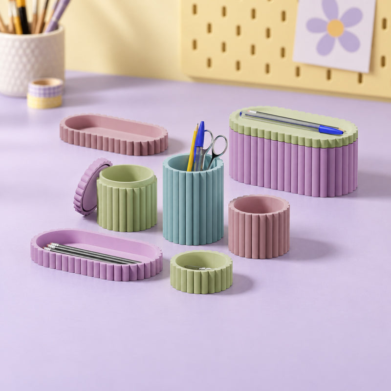 Pastel fluted desk pots, trays and a lidded organizer arranged together in a styled home setting.