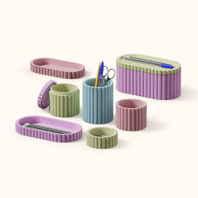 Pastel fluted desk pots, trays and a lidded organizer arranged together on a soft white background.