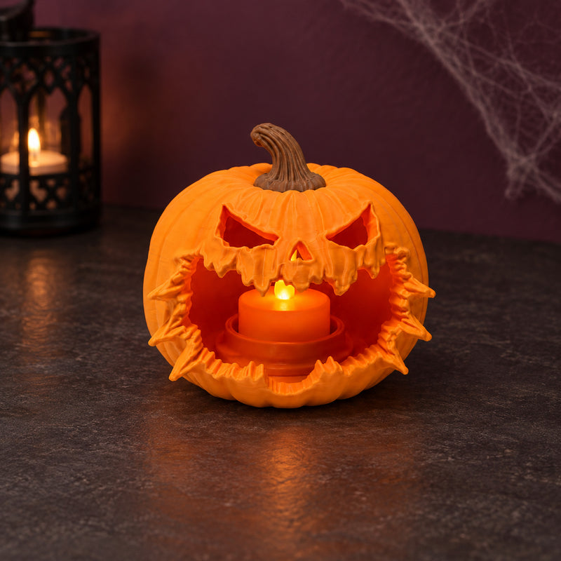 Orange pumpkin lantern with a jagged burst-open mouth and warm light inside in a styled home setting.