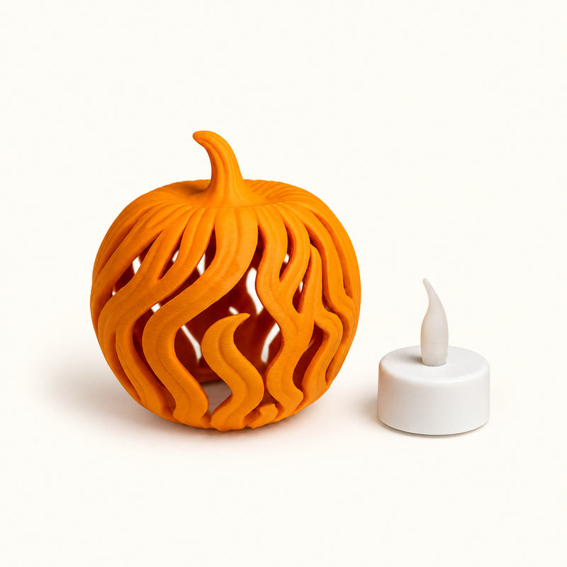 Orange pumpkin with long flame-shaped openings beside a white LED tealight on a soft white background.