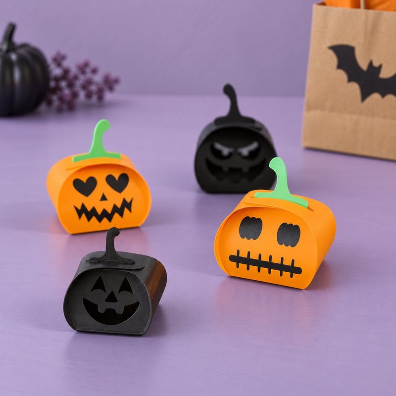 Orange and black folding pumpkin designs with different faces and green stems in a styled home setting.