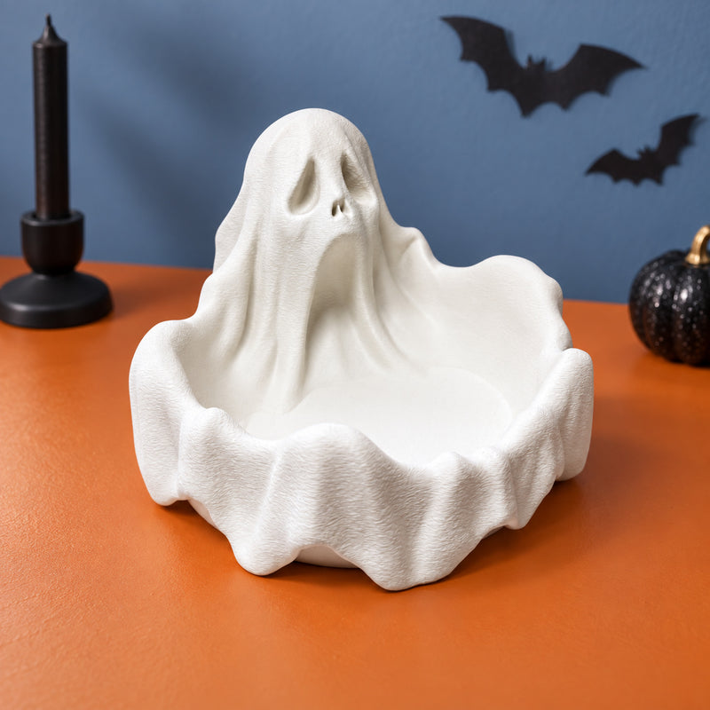 White ghost-shaped bowl with draped sides and an open front compartment in a styled home setting.