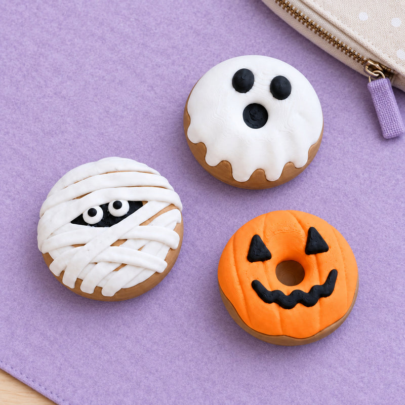 Ghost, mummy and pumpkin donut clickers on a lavender desk mat.