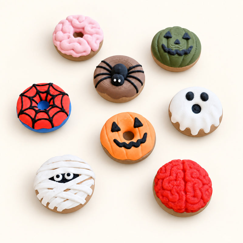 Spooky Donut Keychain Clickers showing the pictured product designs on a warm ivory-white background.