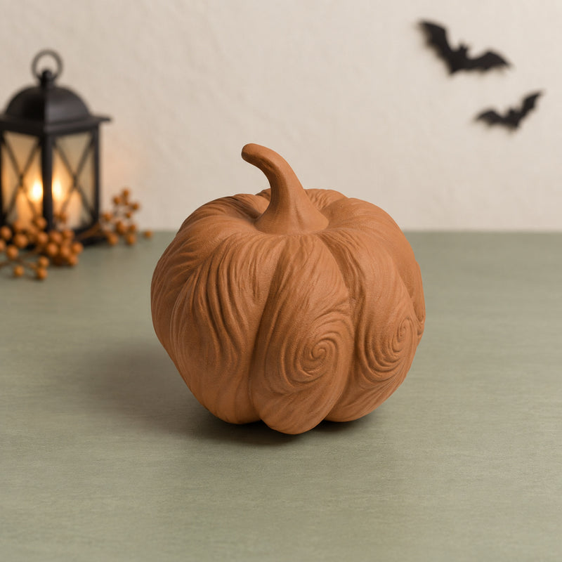 Brown irregular pumpkin decoration with swirling carved-style ridges in a styled home setting.
