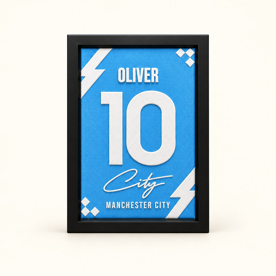 Manchester City jersey frame personalized with OLIVER and the number 10 on a soft white background.
