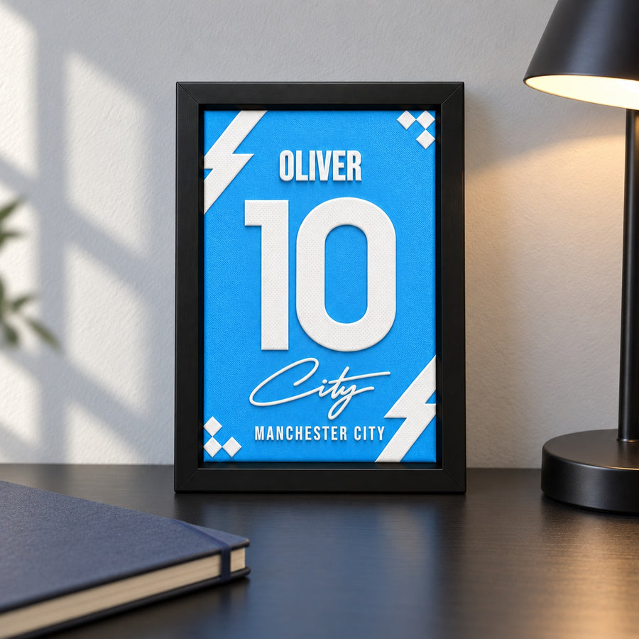 Manchester City jersey frame personalized with OLIVER and the number 10, standing on desk.