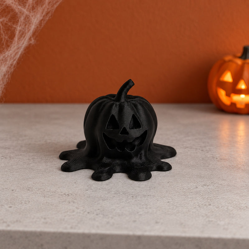 Black jack-o’-lantern decoration with a spreading melting base in a styled home setting.