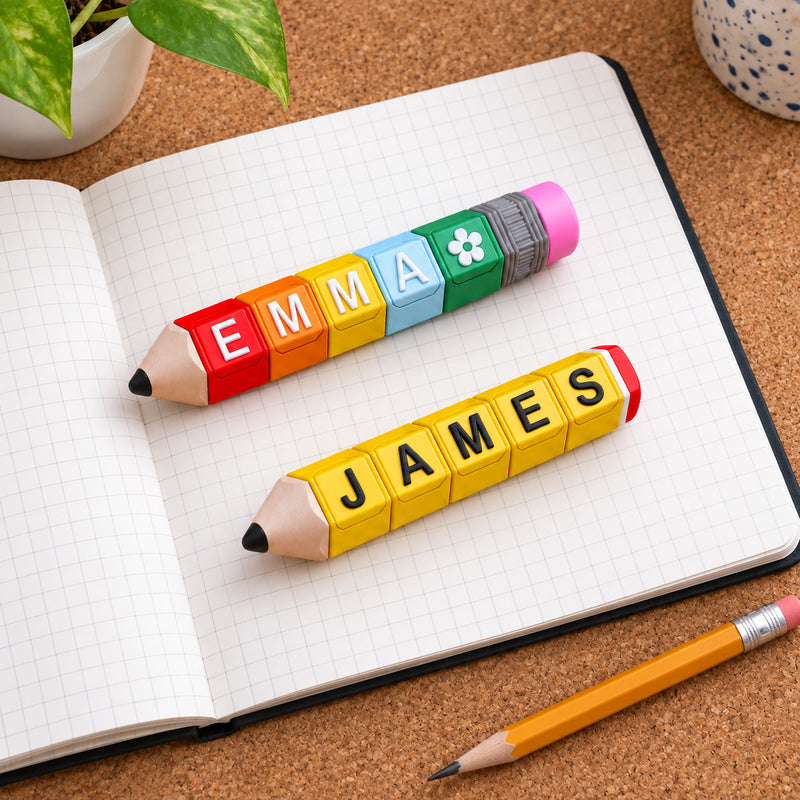 EMMA and JAMES pencil clickers on a squared-paper notebook.