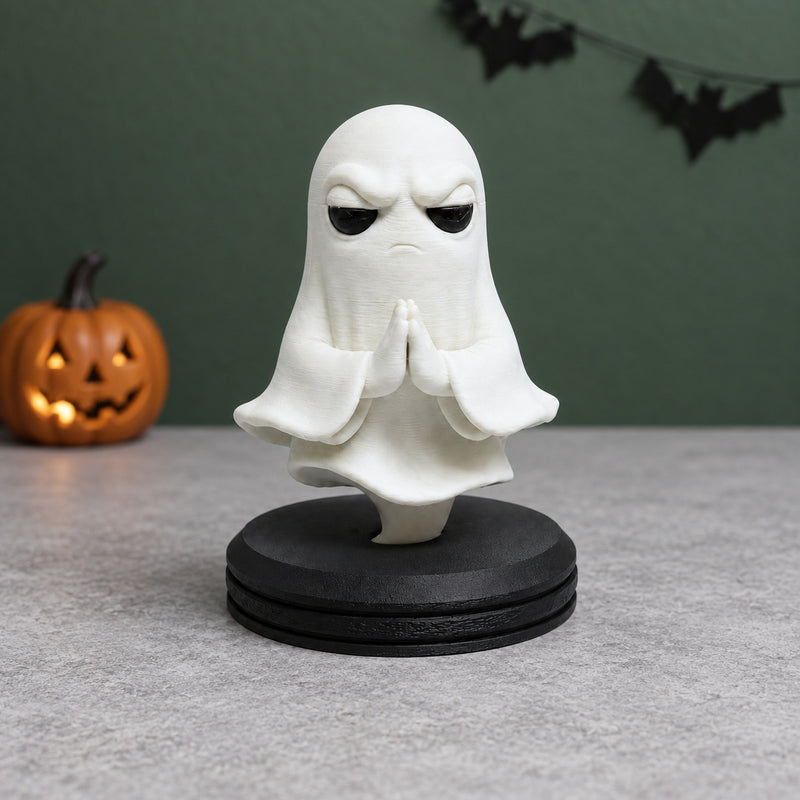 White ghost with folded hands above a black circular pedestal in a styled home setting.