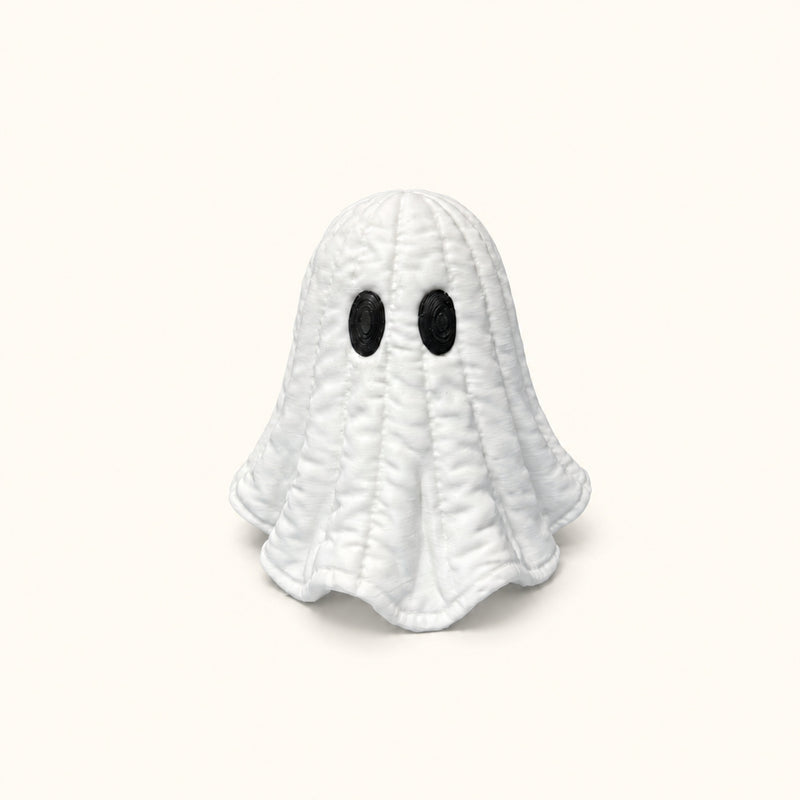 White quilt-textured ghost with black oval eyes on a soft white background.