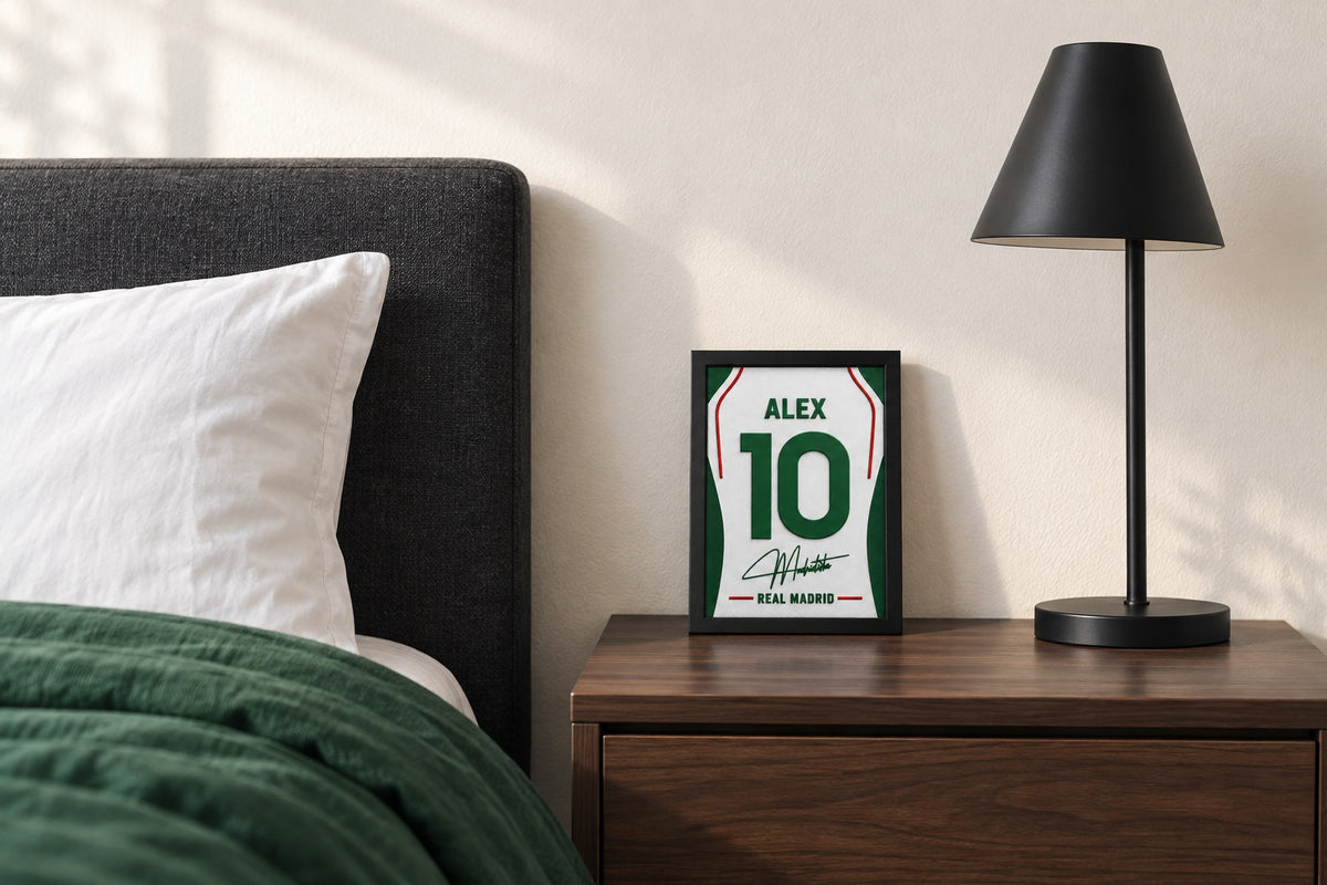 Real Madrid jersey frame personalized with ALEX on a bedside table beside a black lamp and a green duvet.