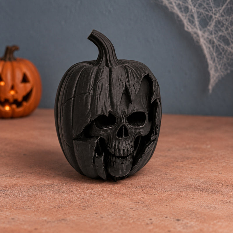 Black pumpkin decoration with a skull face sculpted into the front in a styled home setting.