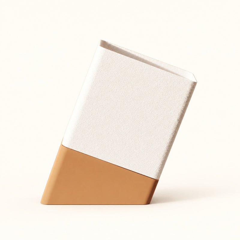 Slanted table lamp with a pale upper section and tan base on a soft white background.
