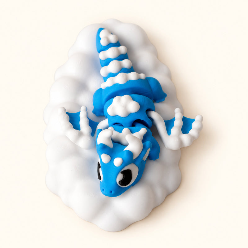Blue and white dragon arranged on a white cloud-shaped base on a soft white background.