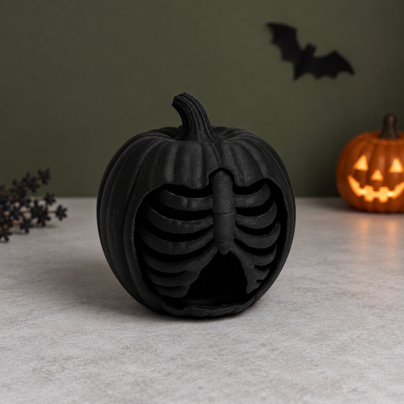 Black pumpkin decoration with rib-like skeletal bars in the front in a styled home setting.