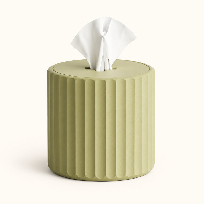Green cylindrical fluted tissue holder with a white tissue emerging from the top on a soft white background.